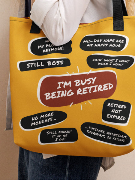 Woman carrying  a yellow tote bag with a large red quote bubble in the center that says, I&#39;m Busy Being Tired. Several black quotes surround it with funny retired people quips such as No More Mondays, Retired Not Expired and many more.