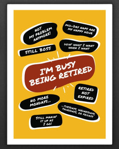 On a dark wall next to a bunch of a golden balloons is a large yellow poster print with large red quote bubble in the center that says, Im Busy Being Retired. Several quotes surround it with funny retirement quips such as, No More Mondays and more.