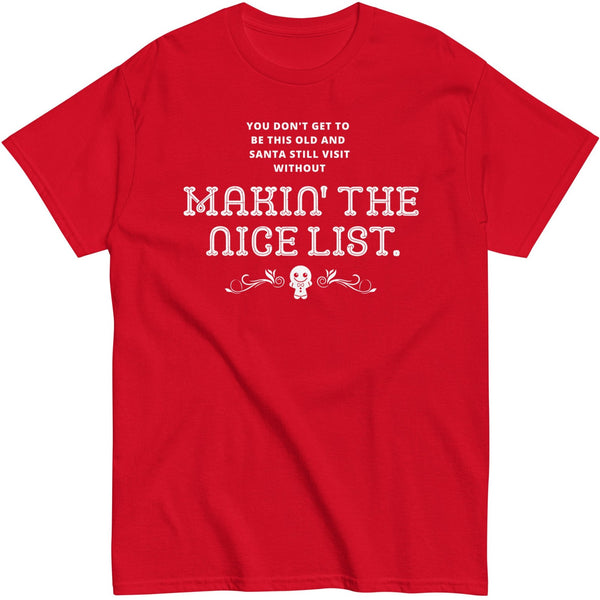 Flat lay mockup against a white background of a red tshirt with text that says, You don't get to be this old and santa still visit without makin' the nice list. A small smiling gingerbread graphic is below the text.